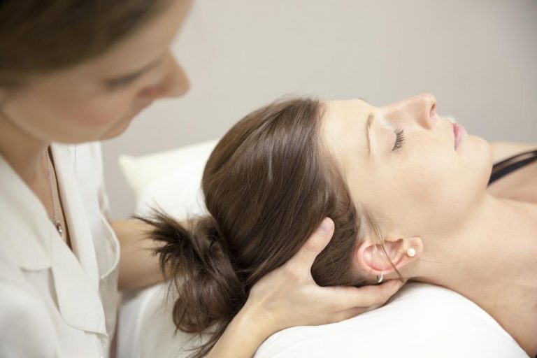chiropractor-adjusting-patient-s-head-and-neck-on-bed