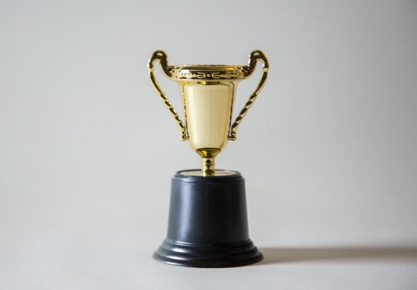 gold trophy on a black base with a plain background
