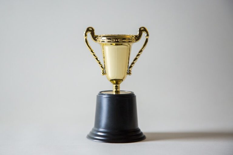 gold trophy on a black base with a plain background