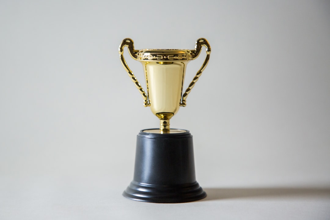 gold trophy on a black base with a plain background