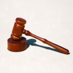 A wooden gavel placed on a round base, symbolizing legal proceedings