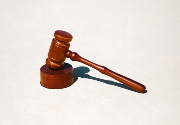 A wooden gavel placed on a round base, symbolizing legal proceedings